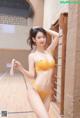 A woman in a yellow lingerie posing for a picture.