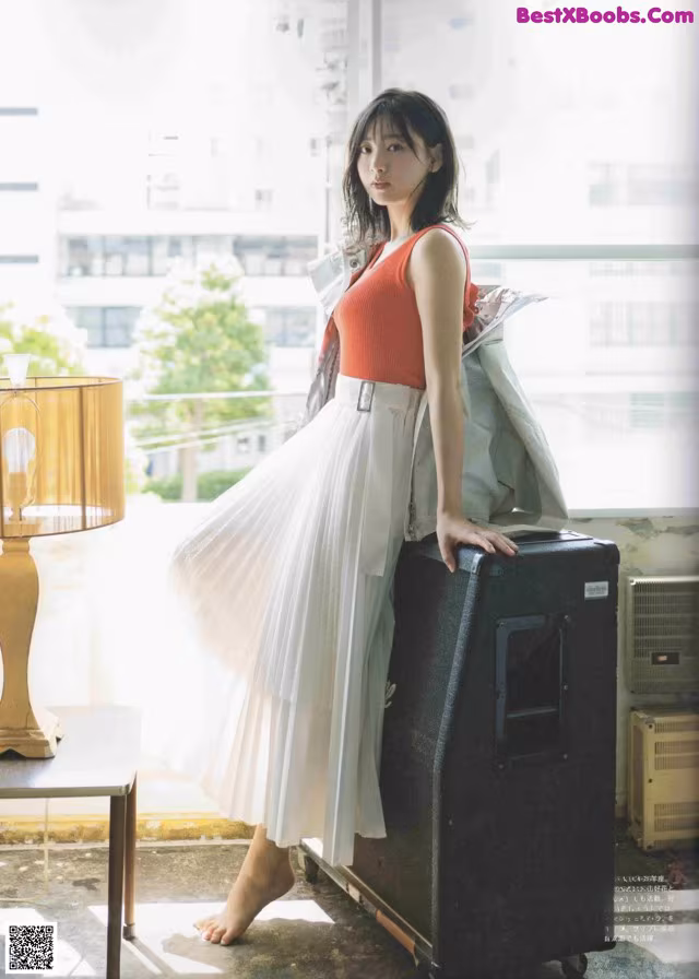 A woman standing next to a suitcase in a room.