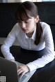 A woman sitting at a table using a laptop computer.