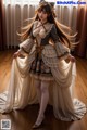 A woman in a dress with long hair standing on a wooden floor.