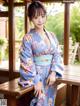 A woman in a blue kimono posing for a picture.