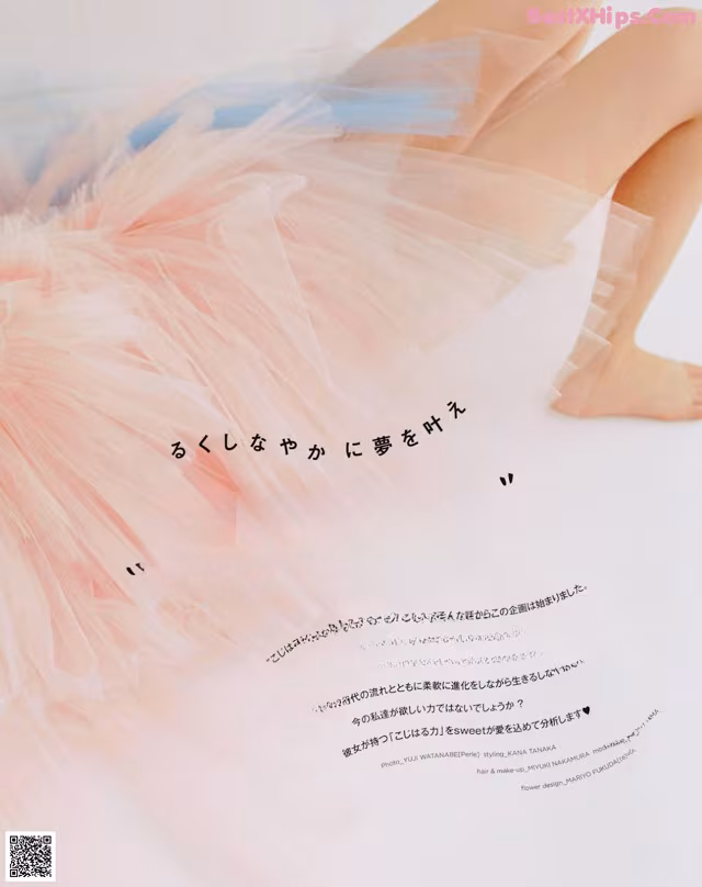 A woman in a pink tutu sitting on a white surface.