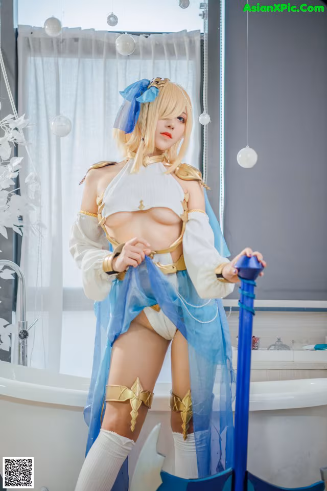A woman in a blue and white outfit holding a sword.