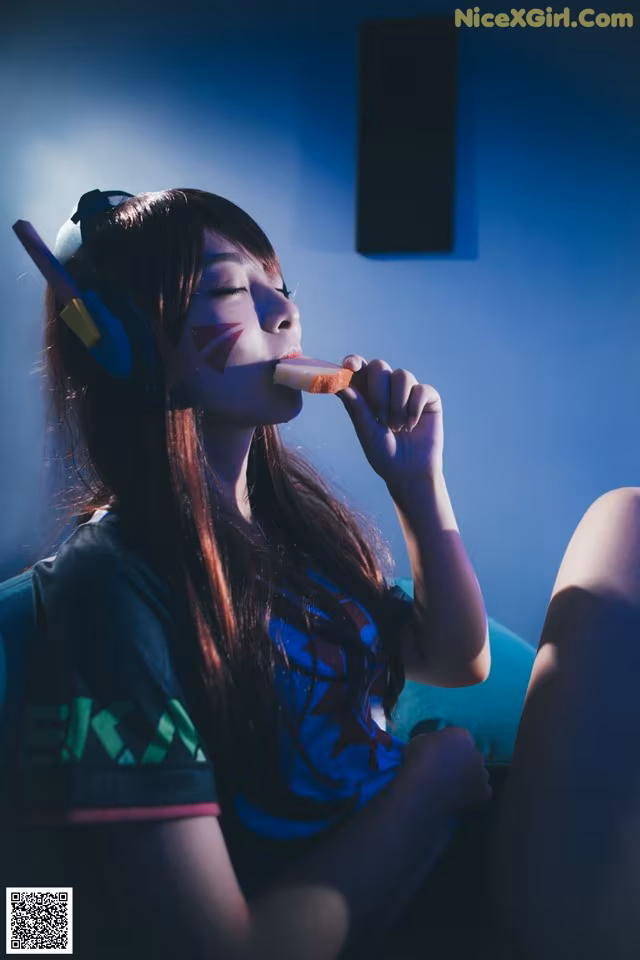 A woman sitting on a couch eating a piece of food.