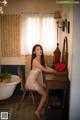 A woman sitting at a desk in a bathroom.