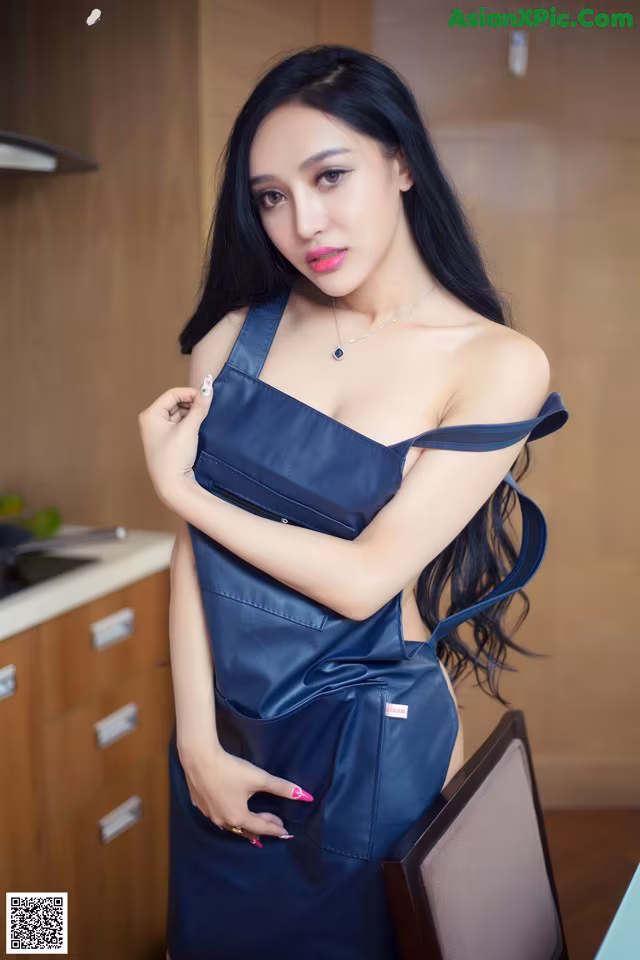 A woman in a blue dress posing for a picture.