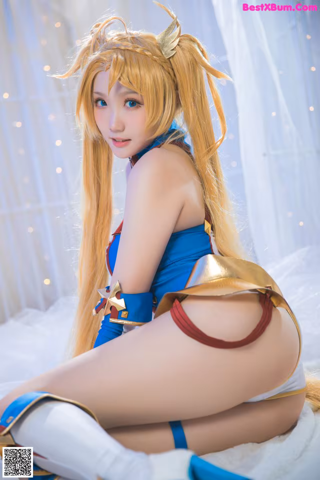 A woman in a blue and red outfit sitting on a bed.