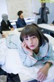 A woman laying on top of a bed in a classroom.