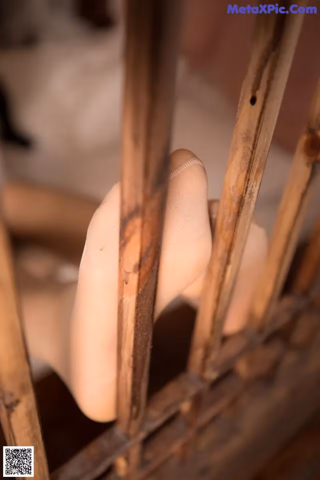 A close up of a person's hand on a wooden chair.