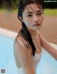 A woman in a white bathing suit sitting in a pool.