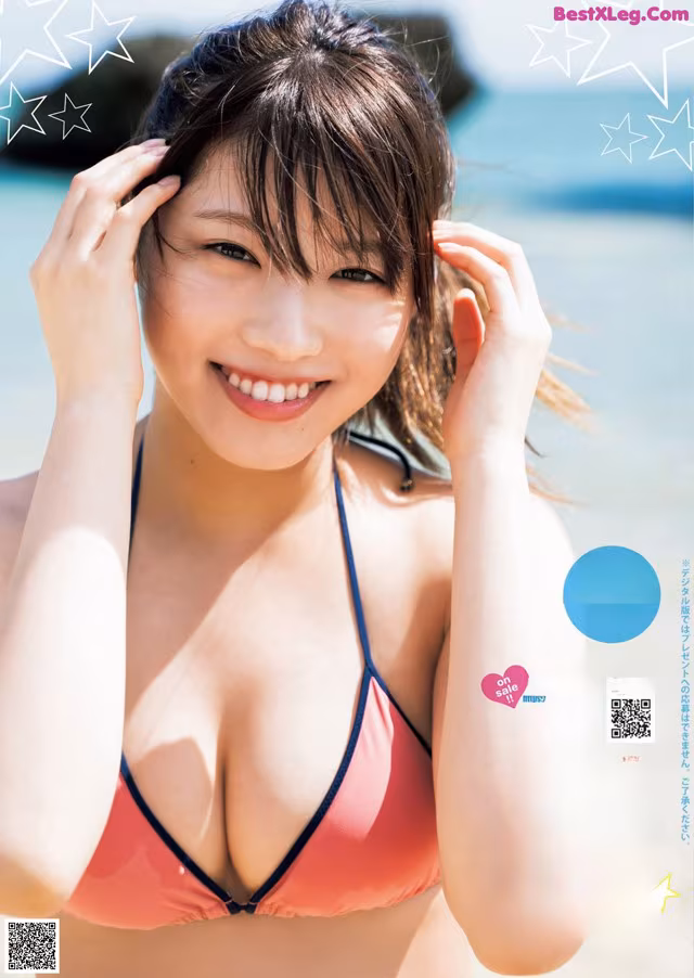 A woman in a bikini posing on the beach.