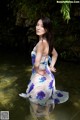 A woman in a blue and white dress standing in the water.